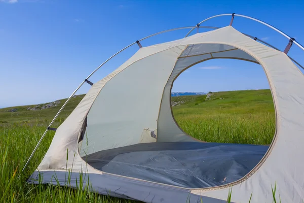 Biały namiot turystyczne, wśród zielonych pól — Zdjęcie stockowe