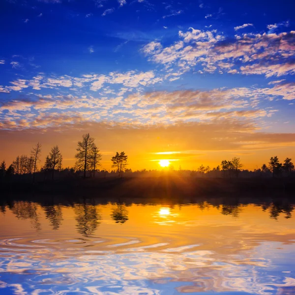 Dramatische zonsondergang weerspiegeld in een water — Stockfoto