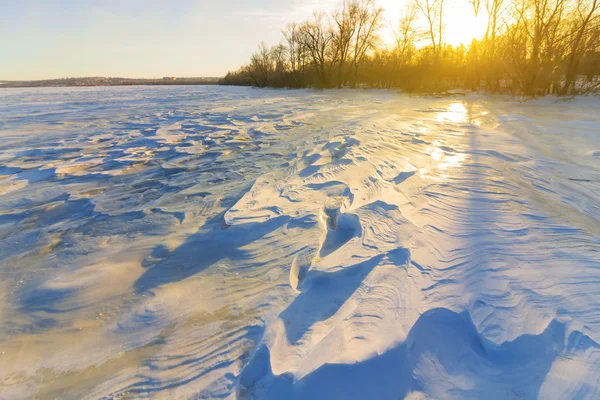 Pôr do sol sobre um campo de neve — Fotografia de Stock