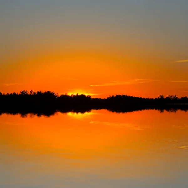 Puesta de sol reflejada en un agua — Foto de Stock
