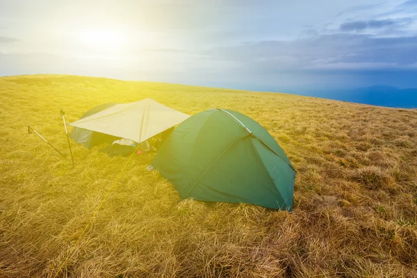 Acampamento turístico entre um campo — Fotografia de Stock