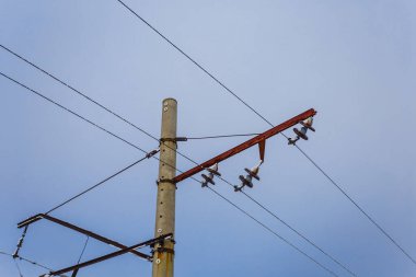 Mavi gökyüzü arkaplanındaki elektrik direğini kapat