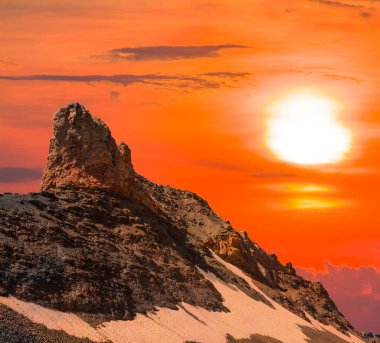 Tek başına dağın zirvesinde kırmızı dramatik arka plan, dağın üzerinde dramatik günbatımı