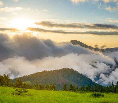 Gün batımında yoğun bulutlarda yeşil dağ