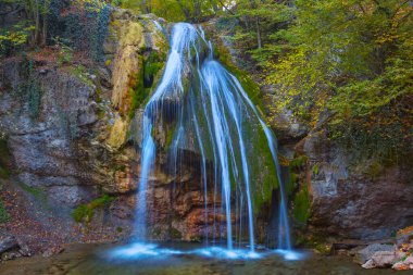 Dağ kanyonunda şelalesi olan küçük dağ nehri, sonbahar açık dağ manzarası