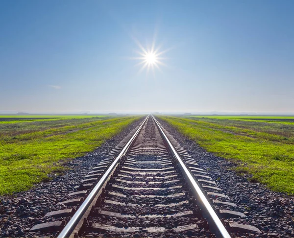 Spoorlijn Tussen Groene Vlakte Onder Een Fonkelende Zon — Stockfoto