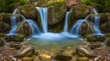 Dağ nehri üzerinde küçük bir şelale, doğal dağ kanyonu manzarası.