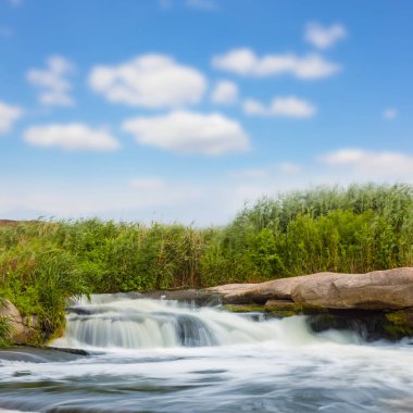 Yaz günü taşlı kıyılar arasında akan nehir.