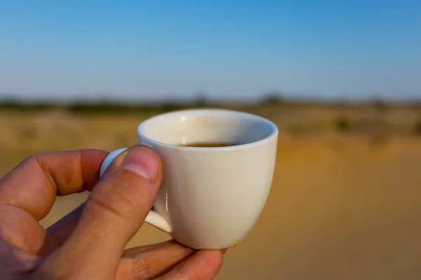 Yakın Plan Insan Eli Kumlu Çölün Ortasında Beyaz Bir Kahve — Stok fotoğraf