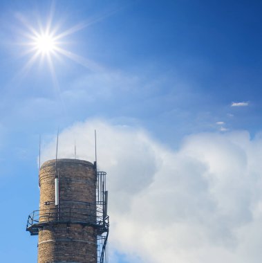 Işıl ışıl güneş altında dumanlı endüstriyel boru