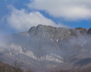 mountain ridge on blue cloudy sky background