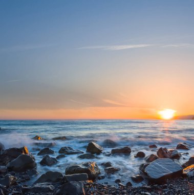 sea coast with stones at the sunset, long exposure outdoor scene