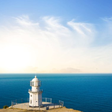lighthouse on emerald marine cape at the sunrise