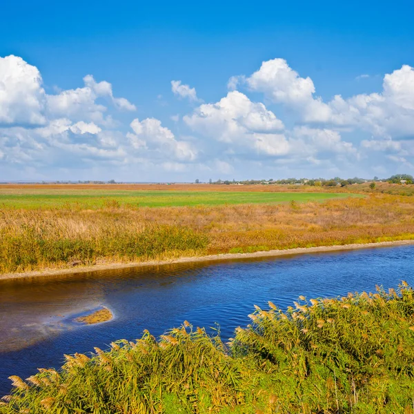 蓝天下的草原间的一条静谧的小河 — 图库照片