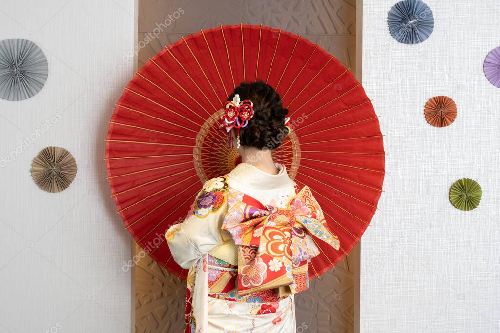 Female adult in kimono with an umbrella spread