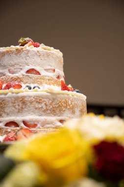 Çiçeklerin arasından düğün pastasına bakıyorum. ...