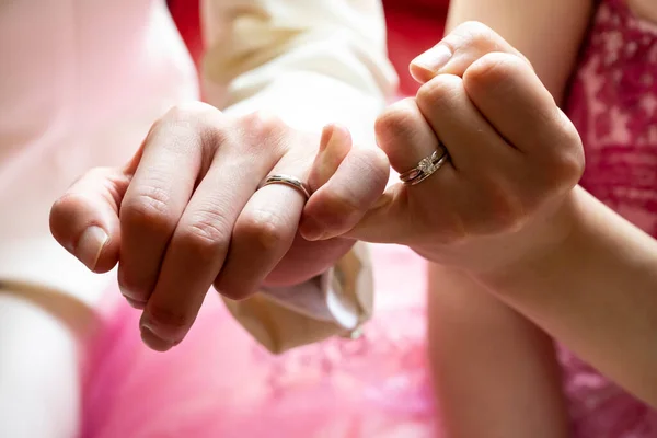 Erkeklerin ve kadınların sol elleri sıkı bir bağla bağlı.