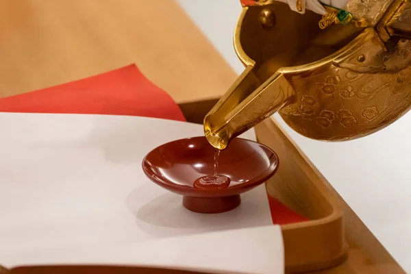 Akrabalar bardağının törenine hazırlanmak için sake dolduruyorum.