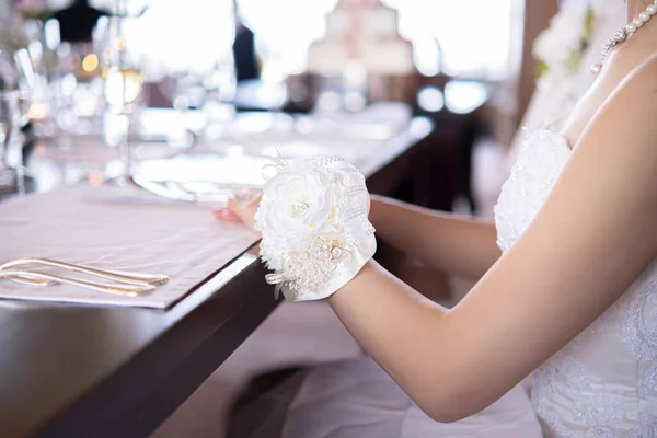 Gelinin bileğine beyaz bir buket bağlanmış.