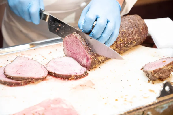 Kızarmış bifteği kesen aşçının eli.