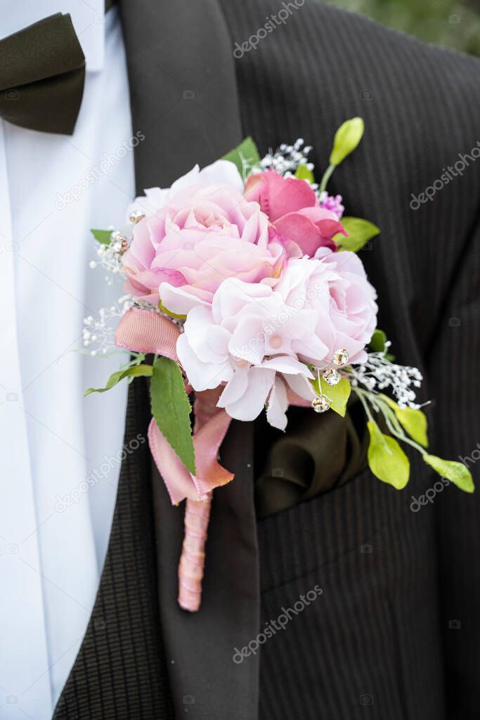Pink rose boutonnire on the groom's chest