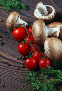 Tahta bir masada taze mantar şampiyonları, domatesler ve baharatlar.. 