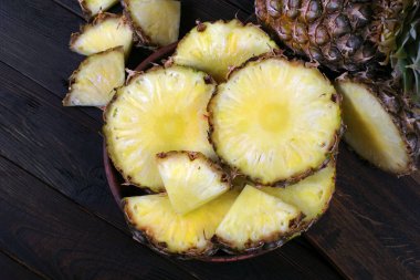 Tahta bir masada olgun ananaslar. Kapat.