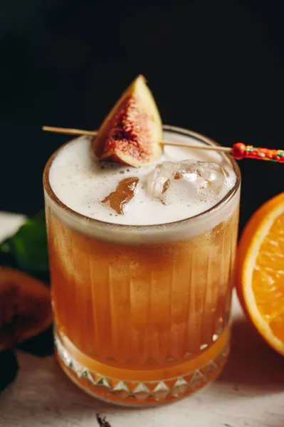 Whiskey sour cocktail with fig in old fashioned glass