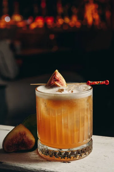 Whiskey sour cocktail with fig in old fashioned glass