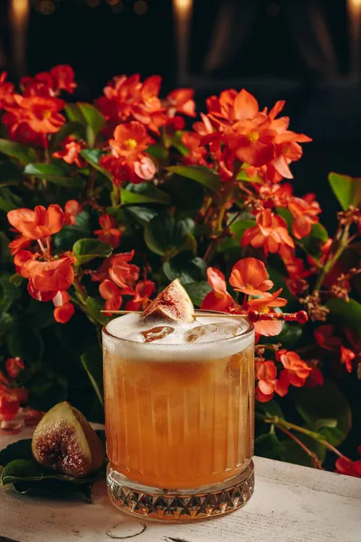 Whiskey sour cocktail with fig in old fashioned glass