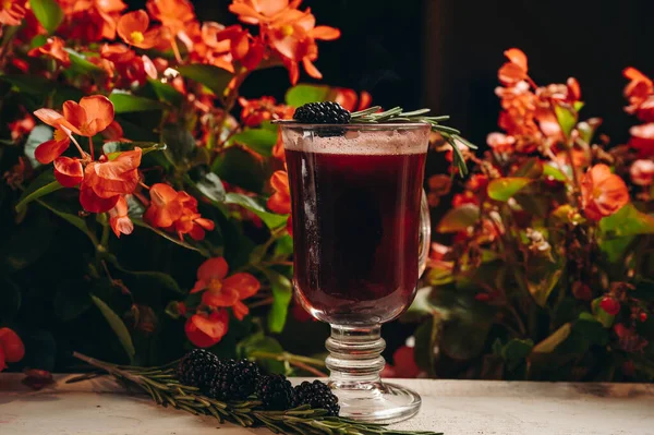 ブラックベリーは 花の背景にガラスのカップにローズマリーとワインを混ぜた — ストック写真