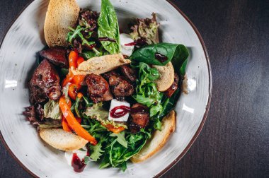 Tavuk ciğeri ve kızarmış ekmek ile sıcak salata karışımı. Restoran yemekleri..