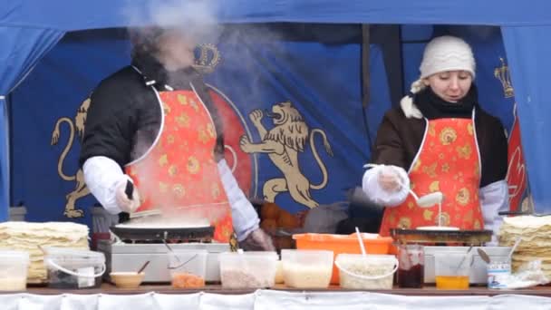 Las mujeres preparan panqueques al aire libre en Kiev en unas vacaciones Shrovetide — Vídeo de stock