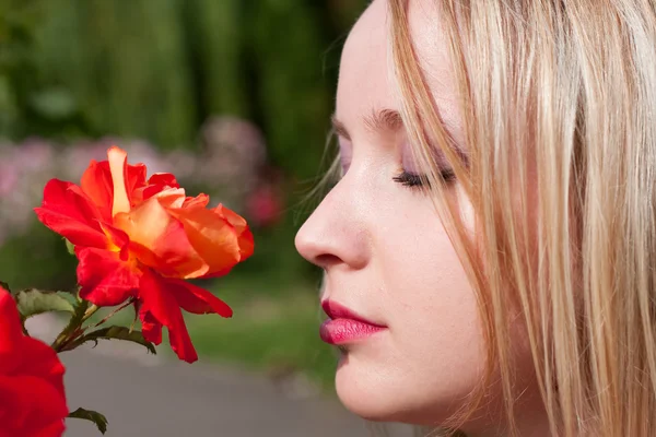 Hermosa chica rubia y flores — Foto de Stock