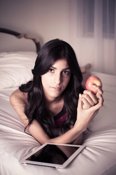 Mujer joven leyendo sosteniendo una manzana — Foto de Stock