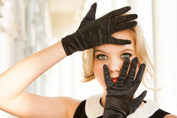 Beautiful woman framing her blue eyes with Black gloves — Stock Photo, Image