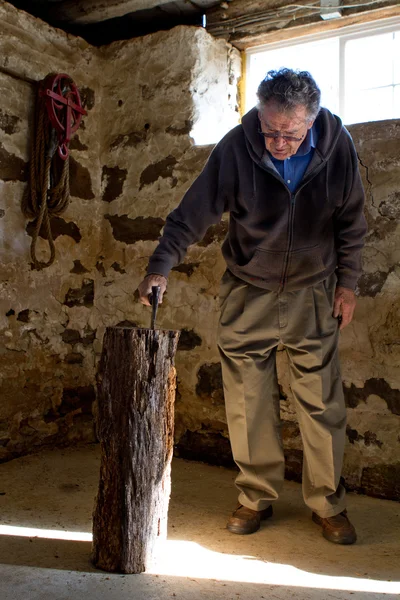 Senior Man grabbing his Axe from in the barn — Stock Photo, Image