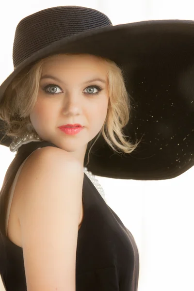 Mulher bonita usando um grande chapéu preto — Fotografia de Stock