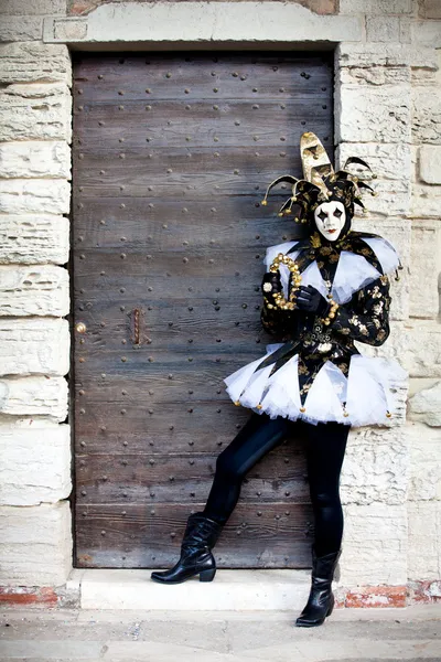 Mooie jester in Venetië Italië door oude gebouw deuropening — Stockfoto