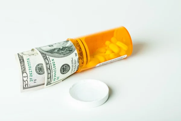 Farmaci da prescrizione in un contenitore con una banconota da un dollaro hunderd — Foto Stock