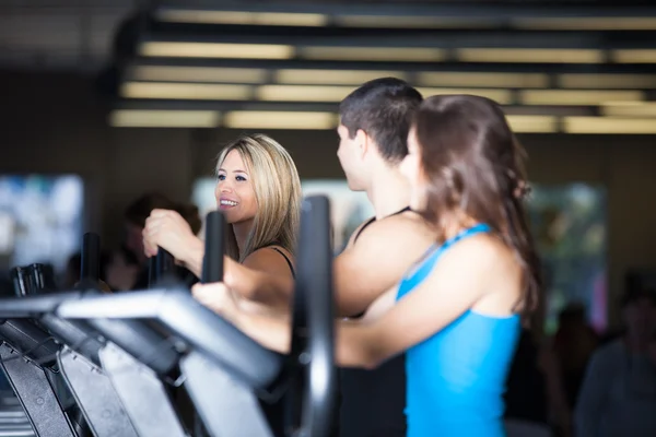 Groep van vrienden uit te oefenen op de sportschool op stair steppers — Stockfoto