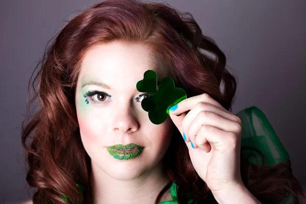 Schöne Frau versteckt ihr Auge mit einem Shamrock — Stockfoto