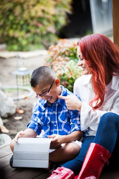 Mãe e filho lendo de uma almofada de toque — Fotografia de Stock