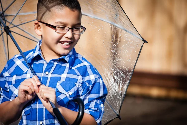 Sonriente joven bajo la lluvia con paraguas — Foto de Stock