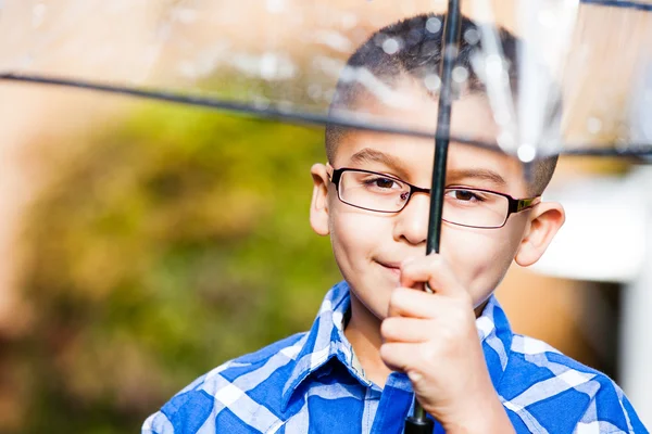 Young boy in the rain with umbrella — Stock Photo, Image