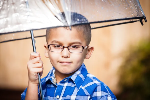 Young boy in the rain with umbrella — Stock Photo, Image