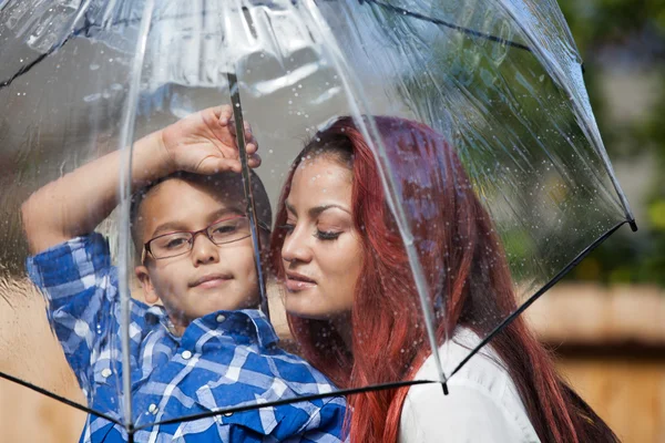 Madre e figlio sotto la pioggia con ombrello — Foto Stock