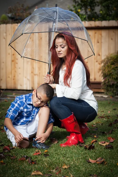 Latin Mère et fils sous la pluie avec parapluie au printemps pour Mot — Photo