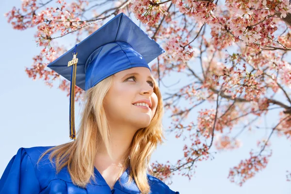 Ganska ung 2013 examen under blommande körsbärsträd — Stockfoto