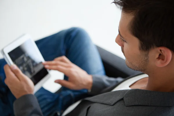 Goed uitziende man in zijn bezig met een mini denk pad 20s — Stockfoto